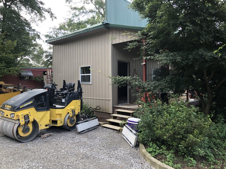 A little storage house on the property is converted to a cabin for guests while a driveway is prepared