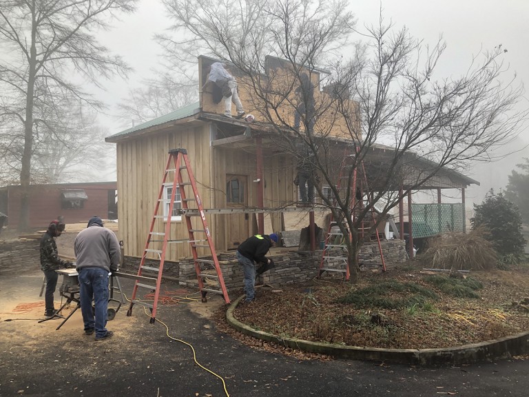 At this stage, stone and concrete replaces the old railroad ties the previous builder used for a foundation, plastic siding has been replaced by locally milled poplar, and the roof is well underway